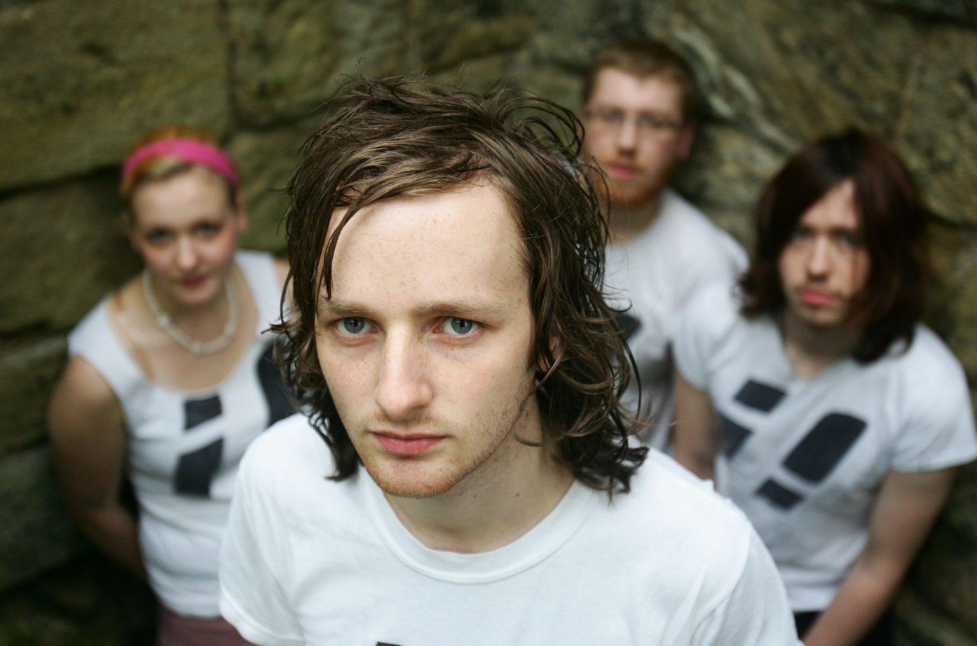 band of 4 posing against wall