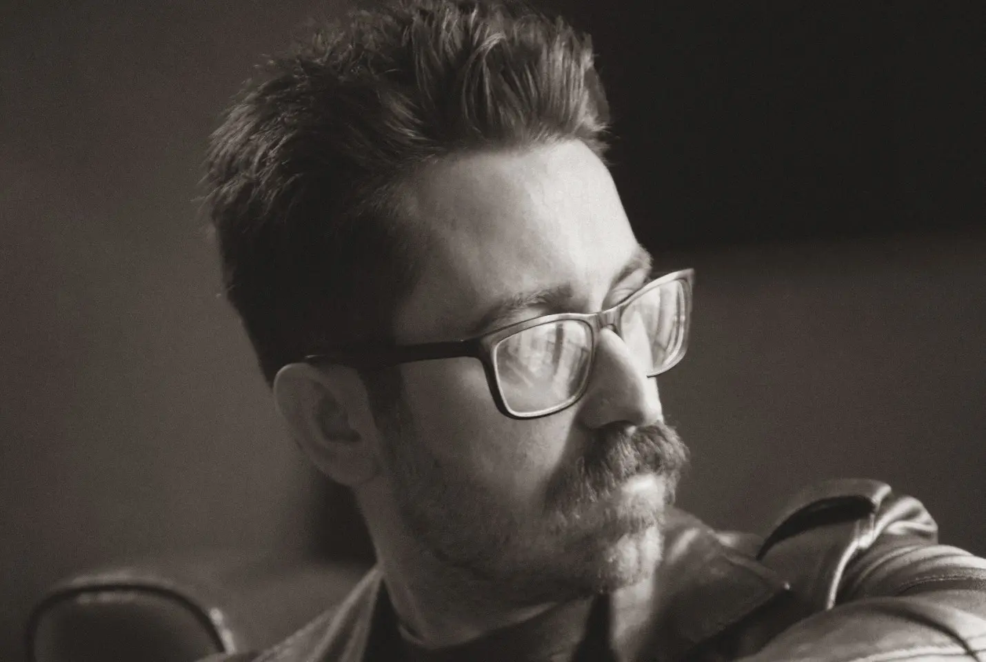 black and white portrait of a man in glasses looking to his left