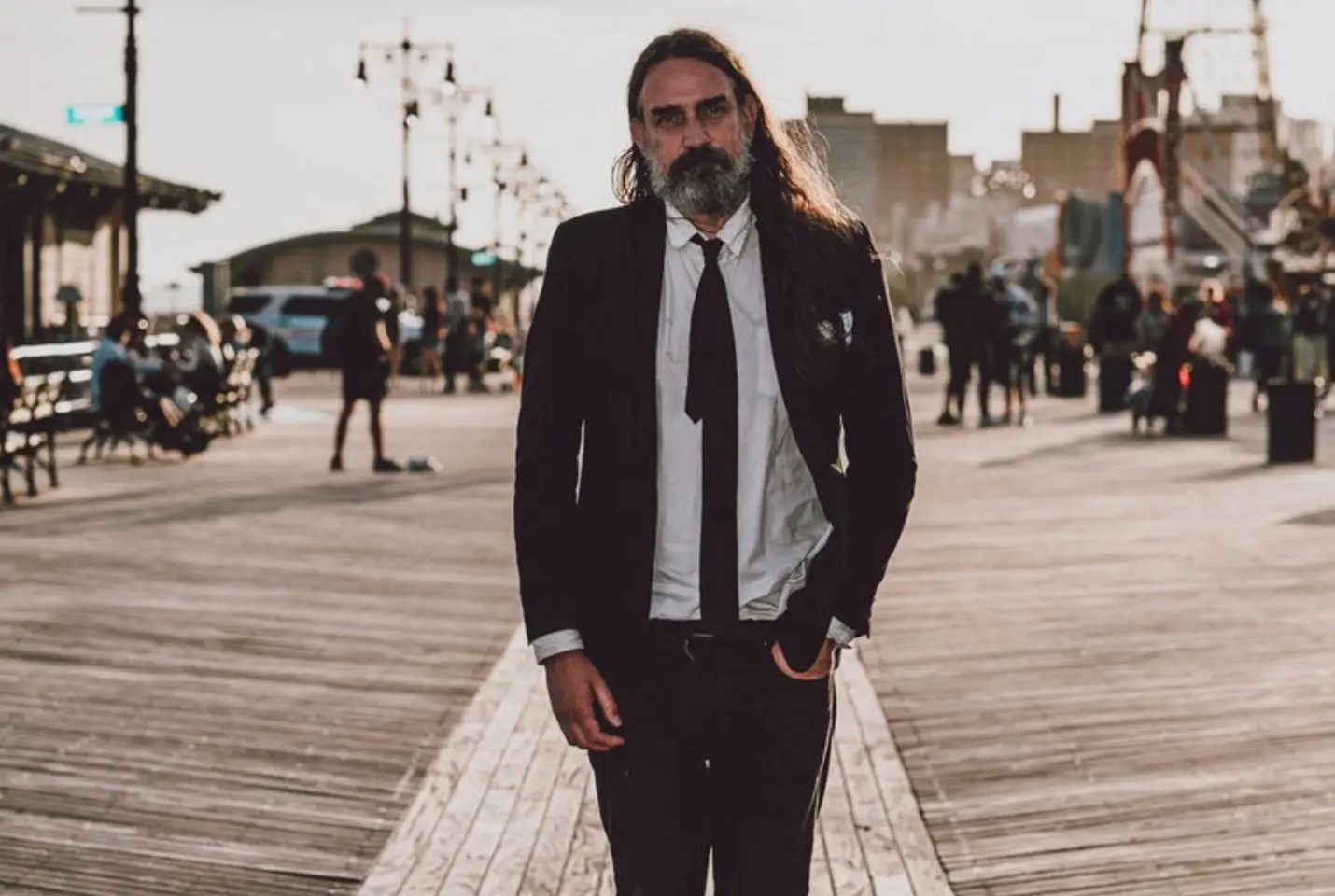 man walking along beach in suit