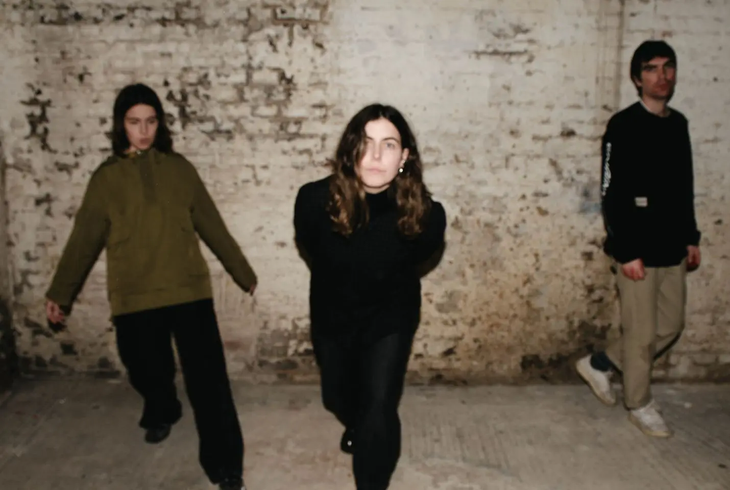 Trio Voka Gentle in front of a brick wall