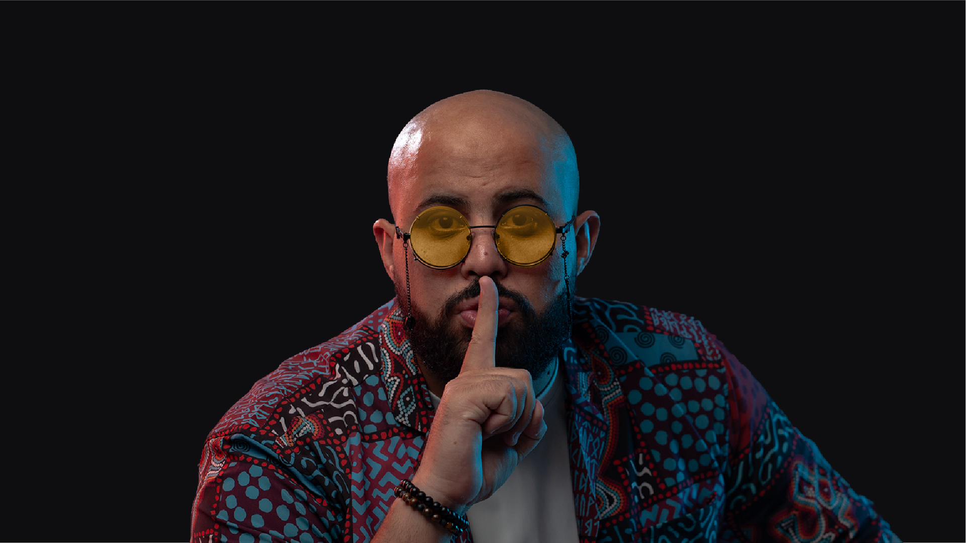 man colorful shirt, bald, black rim glasses, beard