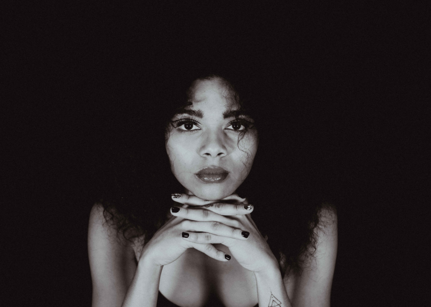 Black and White image of Brooke Combe with head leaning in hands.