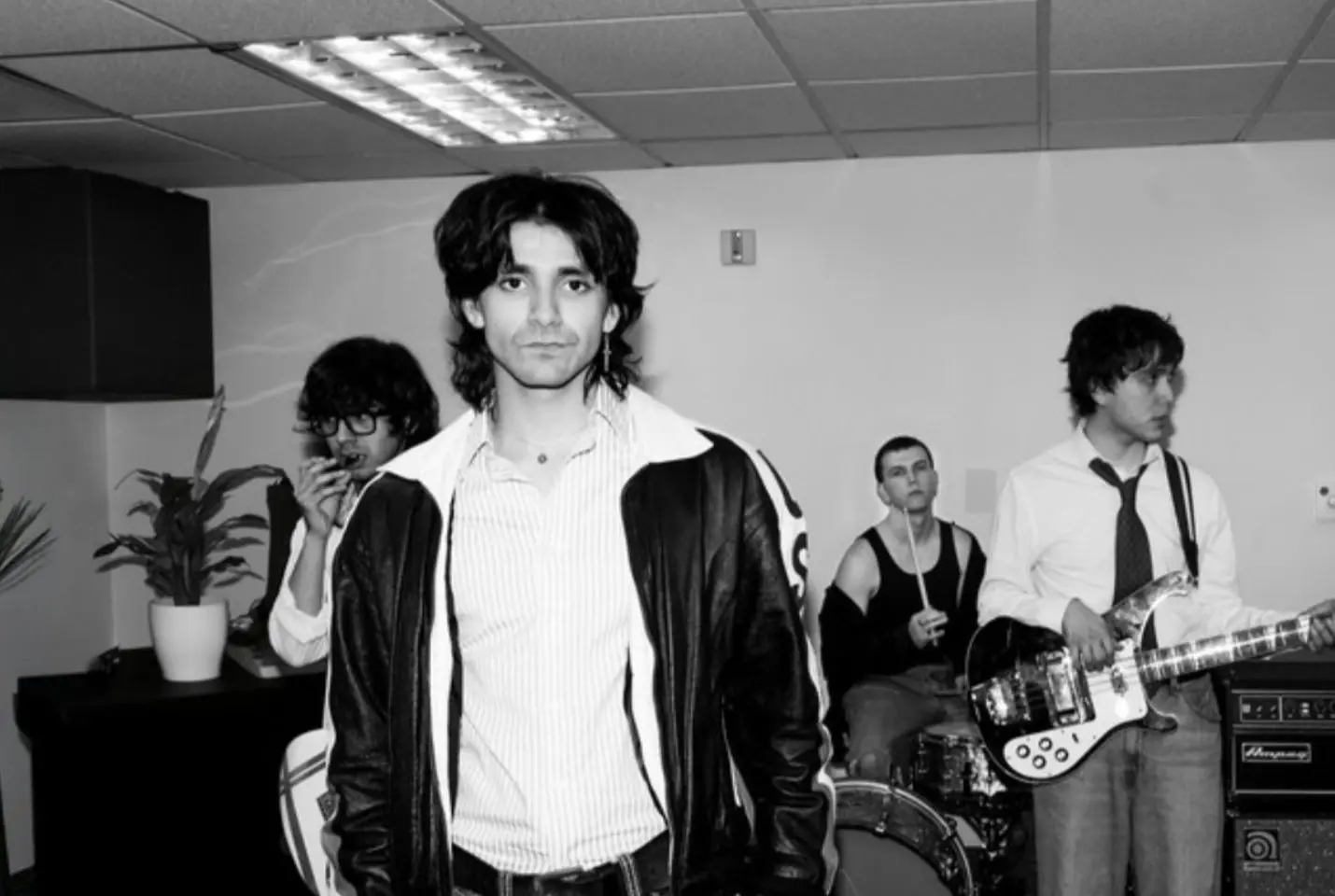 black and white image of four man in a music practice room