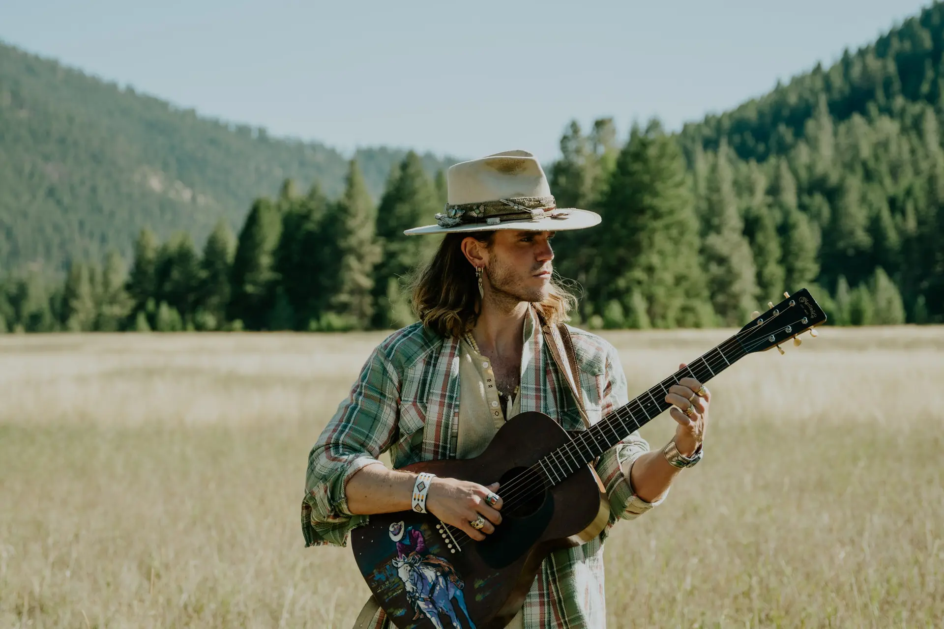KALEO holding guitar in the field