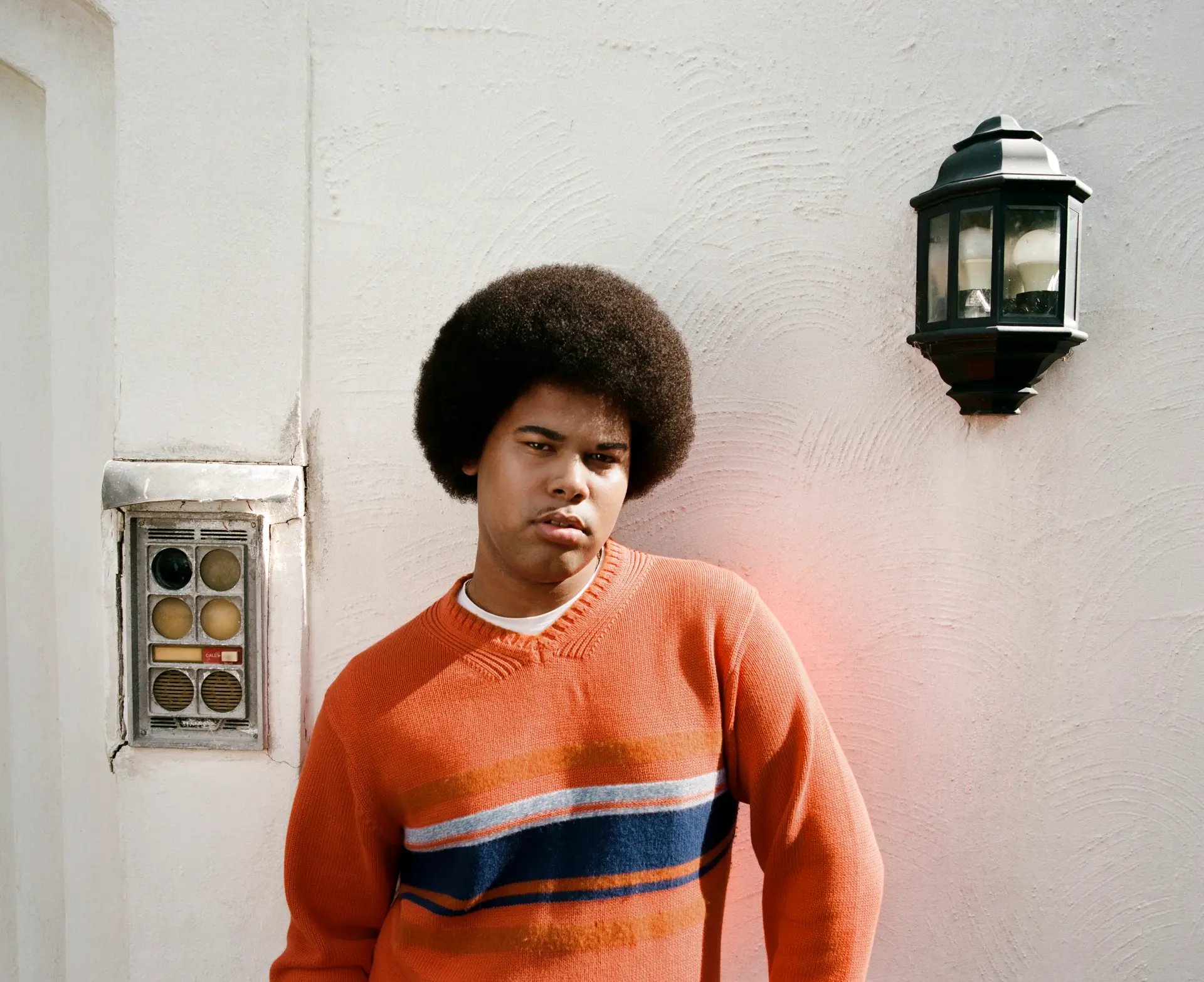 sekou posing in colourful sweater