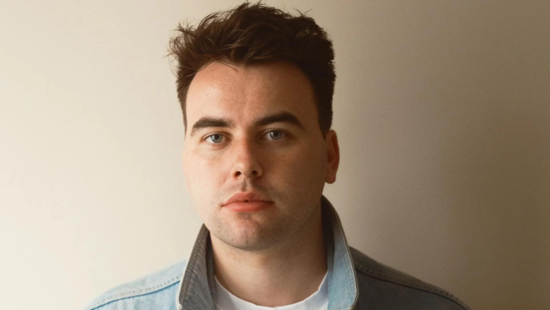 Jamie Rafferty wearing a white tshirt and blue denim jacket