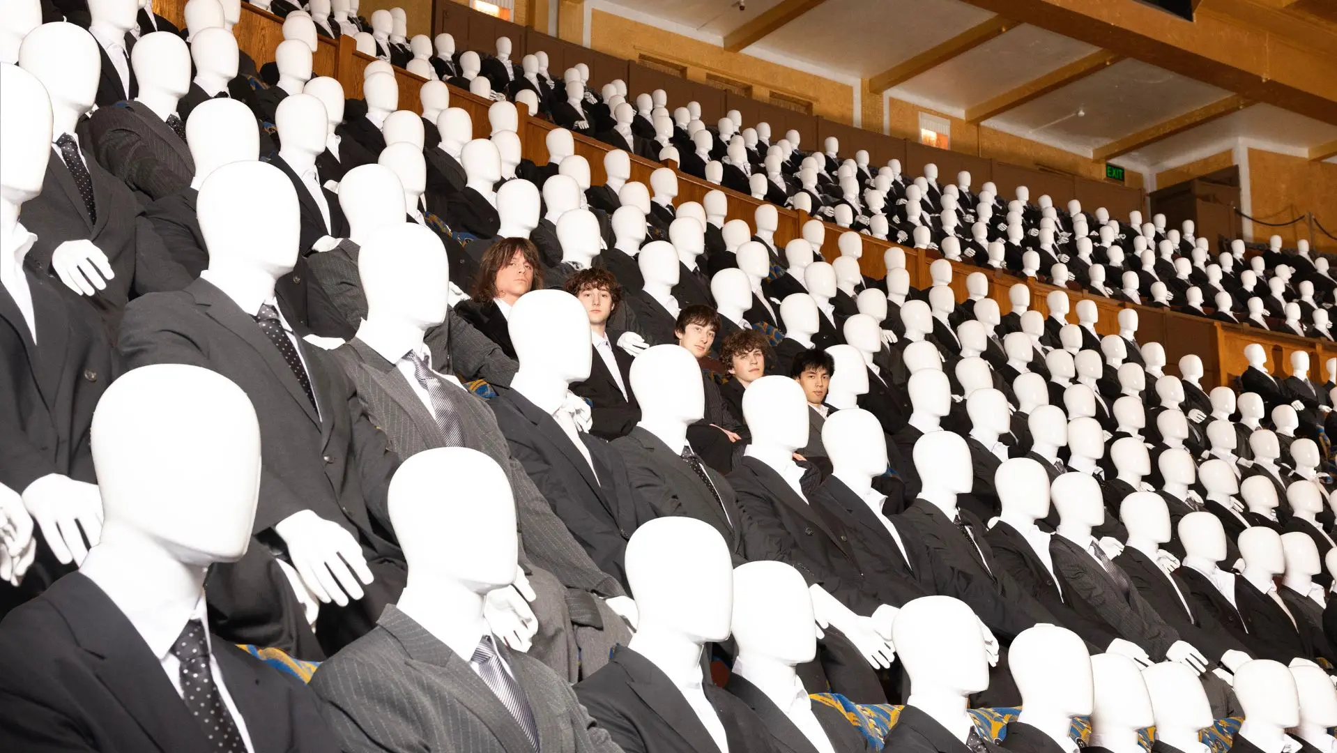 The Guest List sat in an auditorium surrounding by people in suits