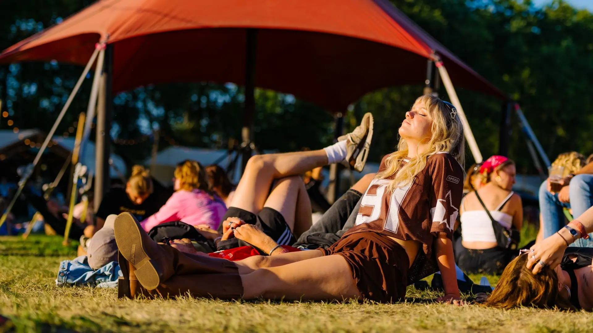Mensen die buiten zitten te genieten van de zon on Lowlands