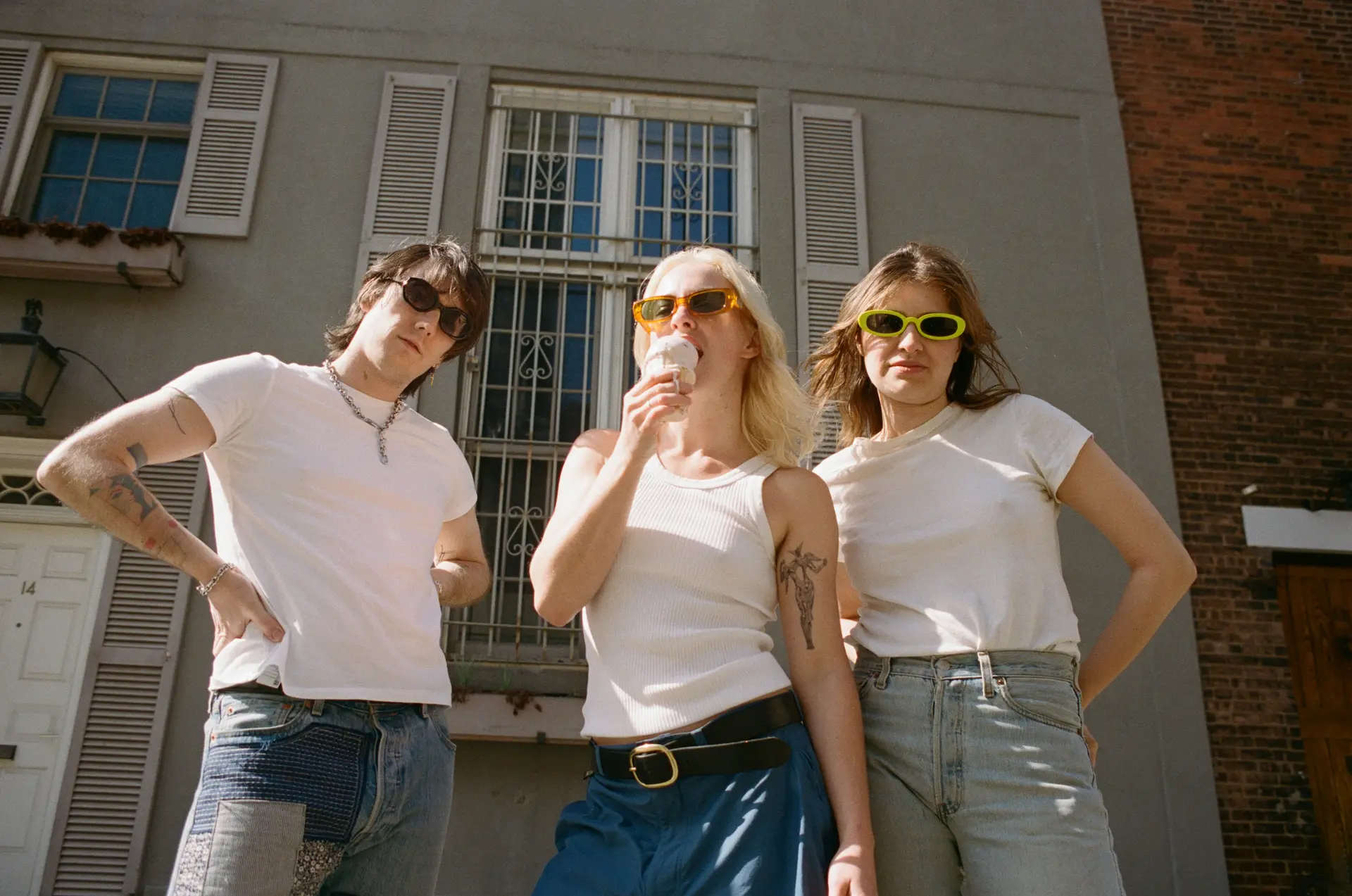 Three people stood wearing white tshirts and blue jeans