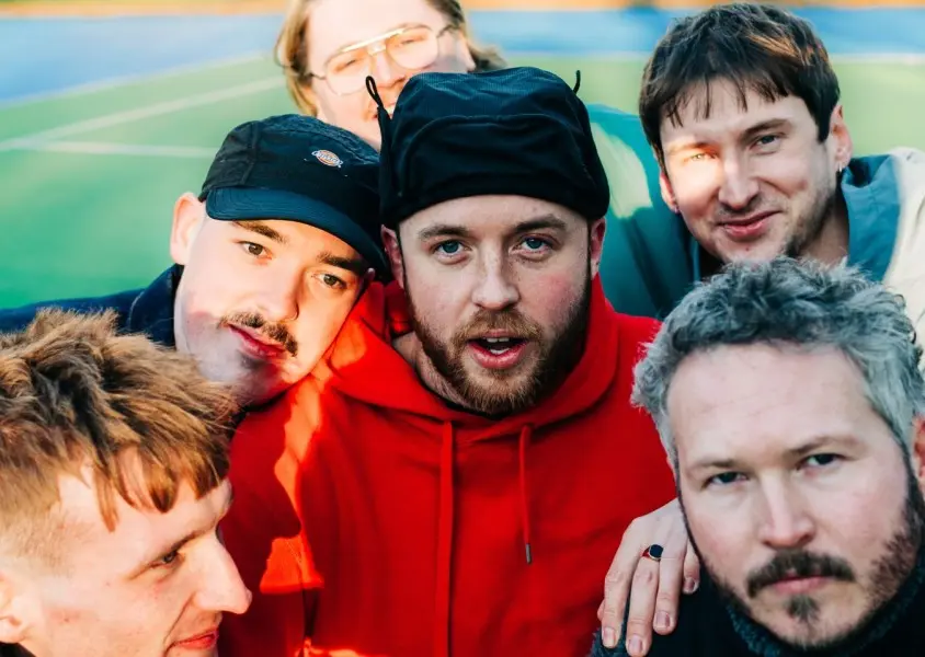 A close up of of six men stood on a tennis court