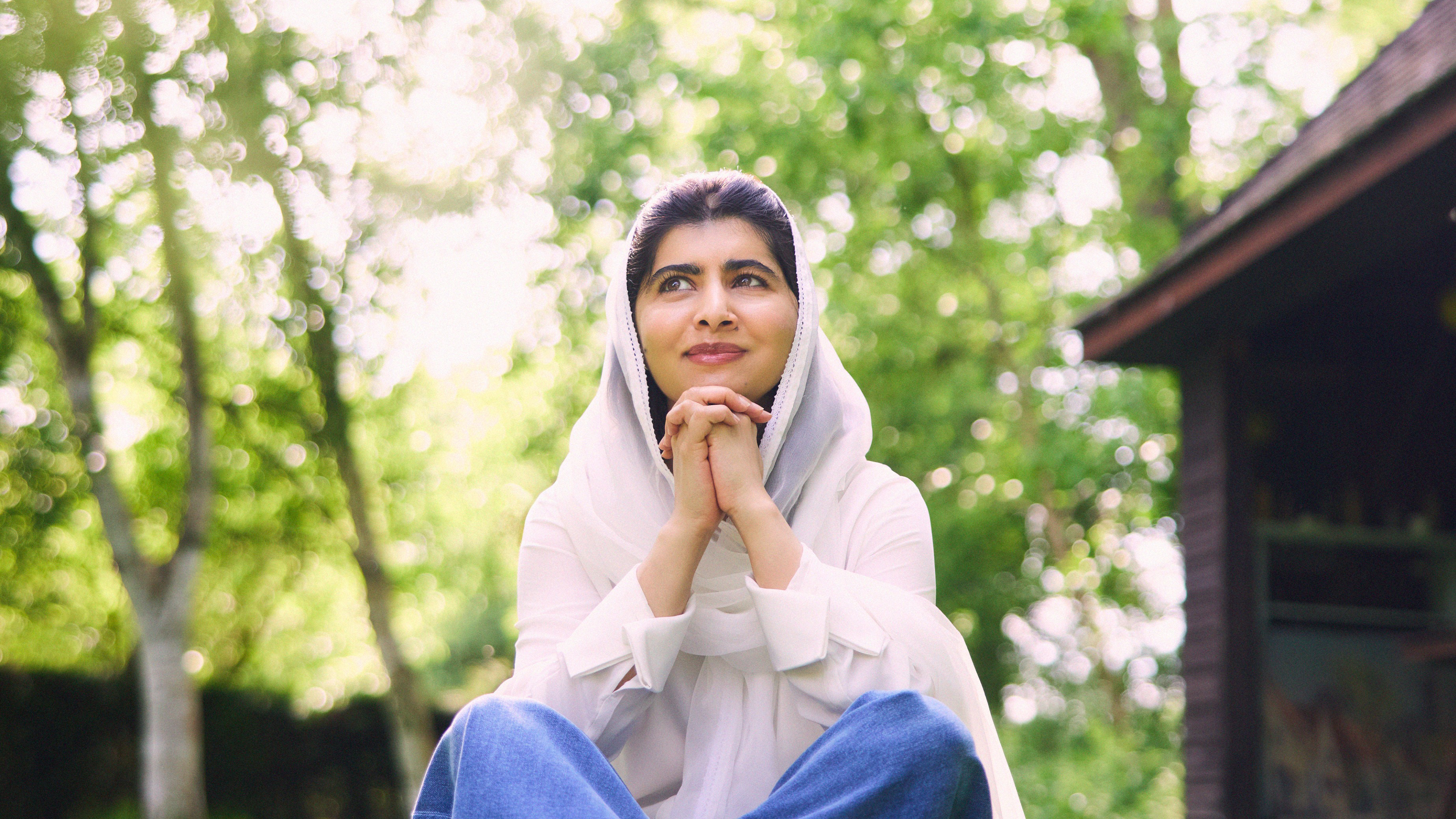 Malala Yousafzai sitting in grass
