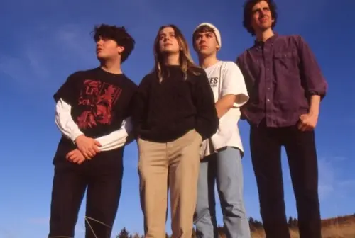 four men posing against blue sky