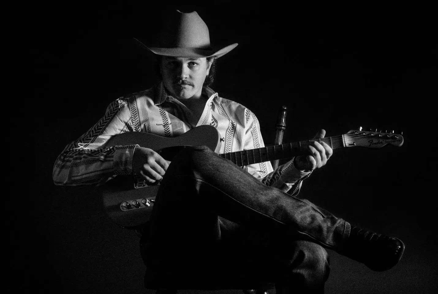 Zach Top sat holding a guitar