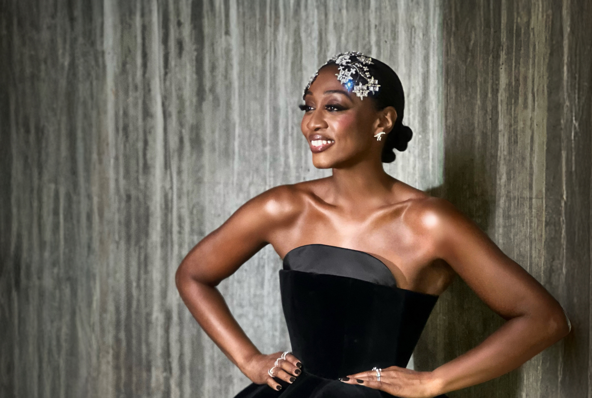 Beverley Knight standing with hands on hips in a black gown.