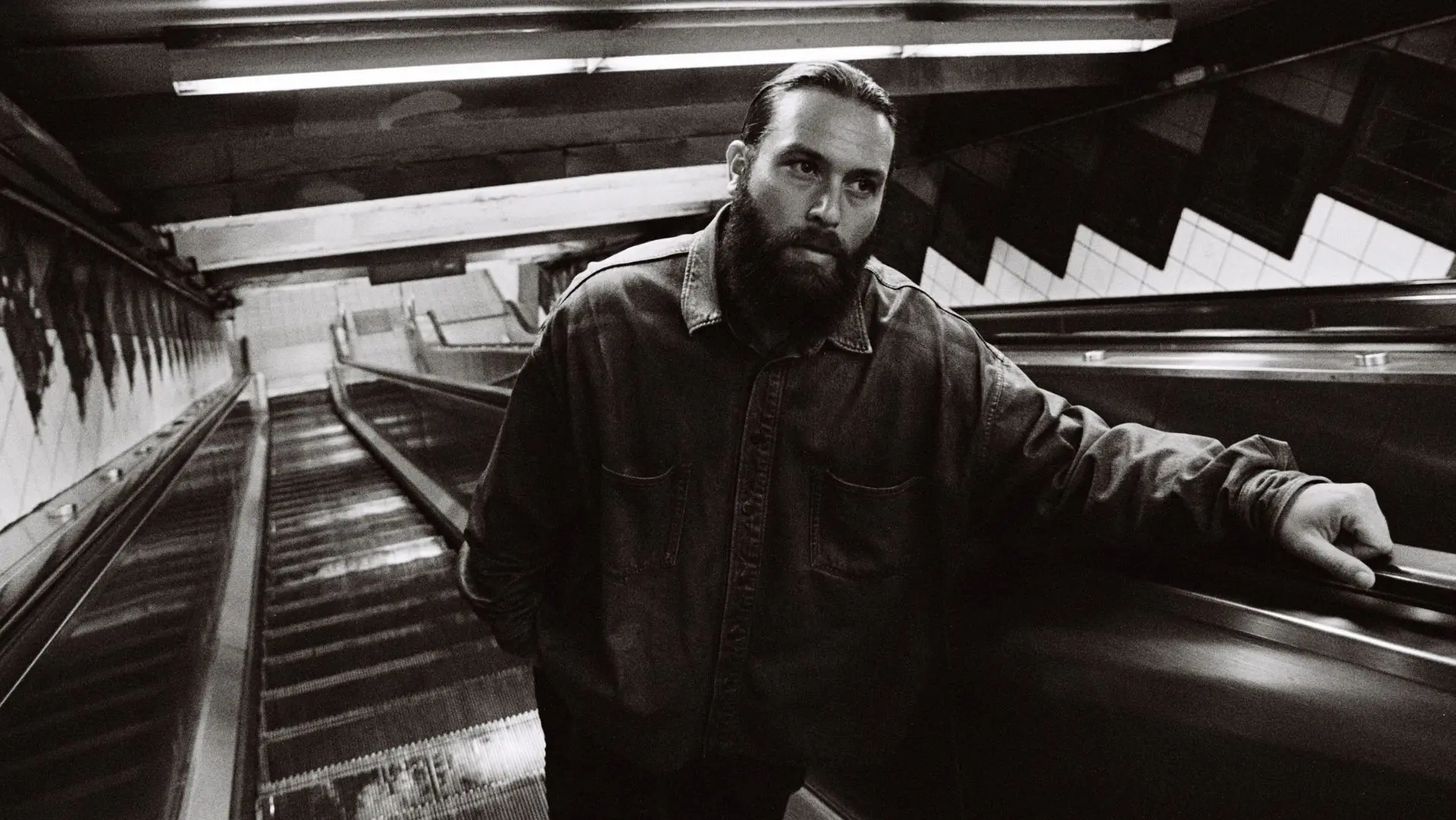 Black & White image of Nick Hakim on an escalator