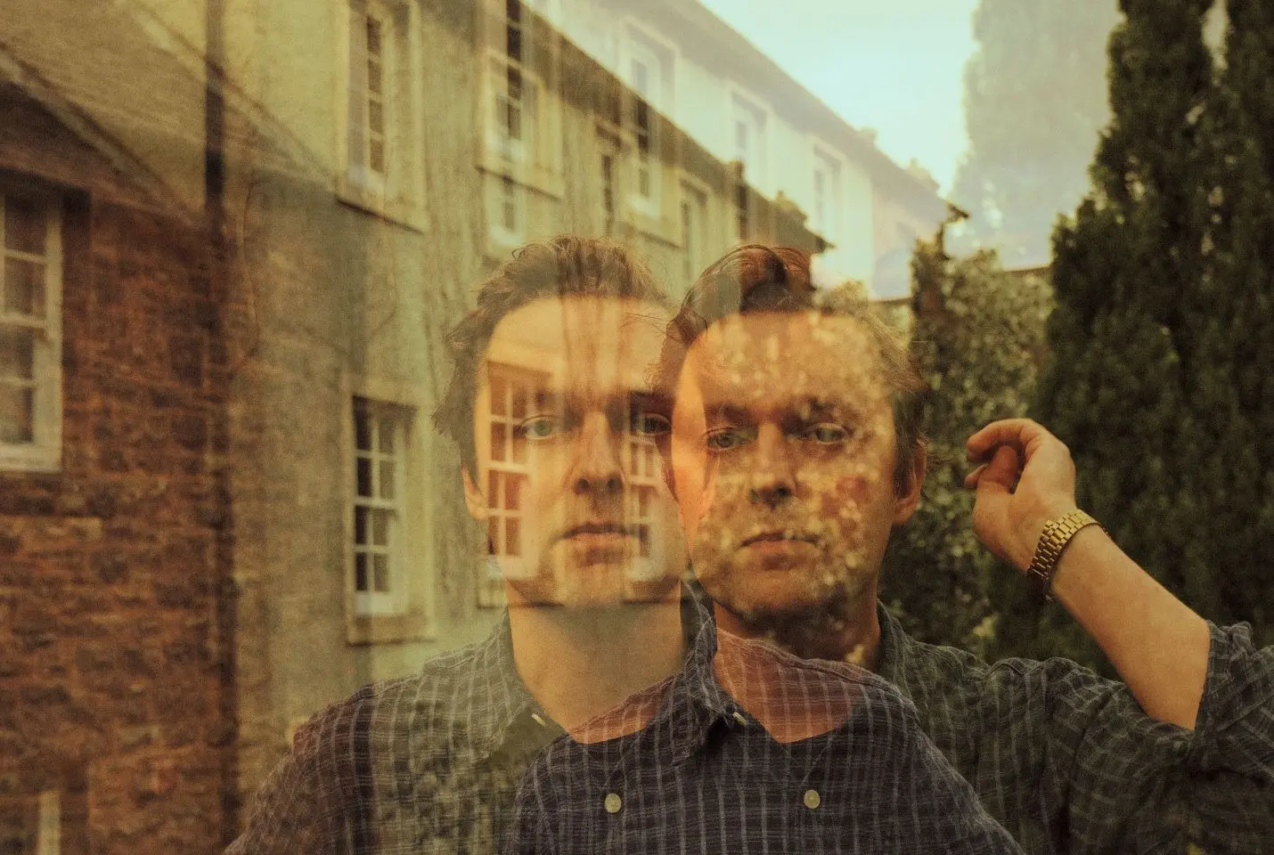 Joshua Burnside in a blue check shirt and gold watch