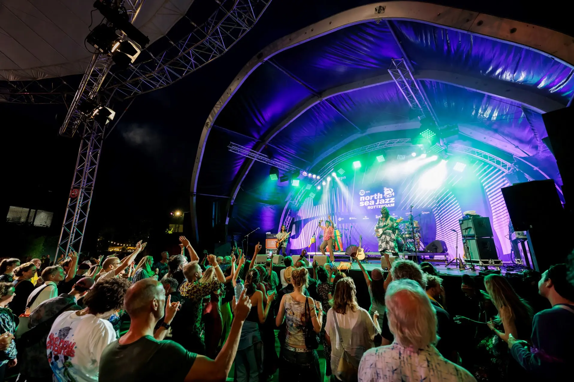 Een avondoptreden op het NN North Sea Jazz Festival, waar kleurrijke lichten en meeslepende muziek zorgen voor een bruisende sfeer.