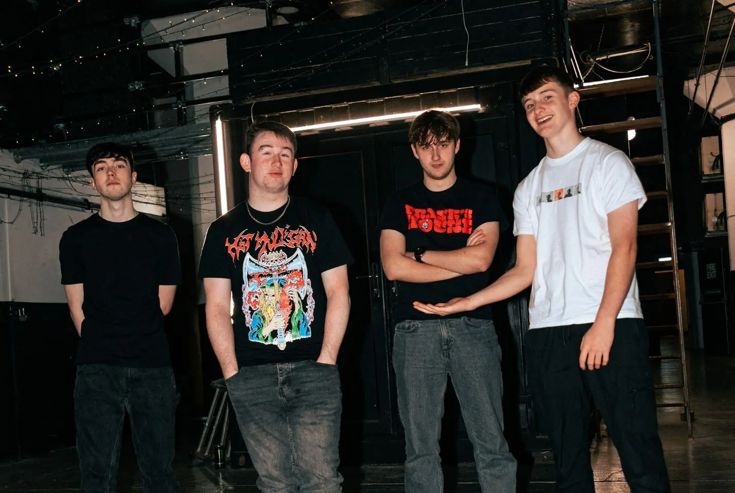 4 men posing in dark venues
