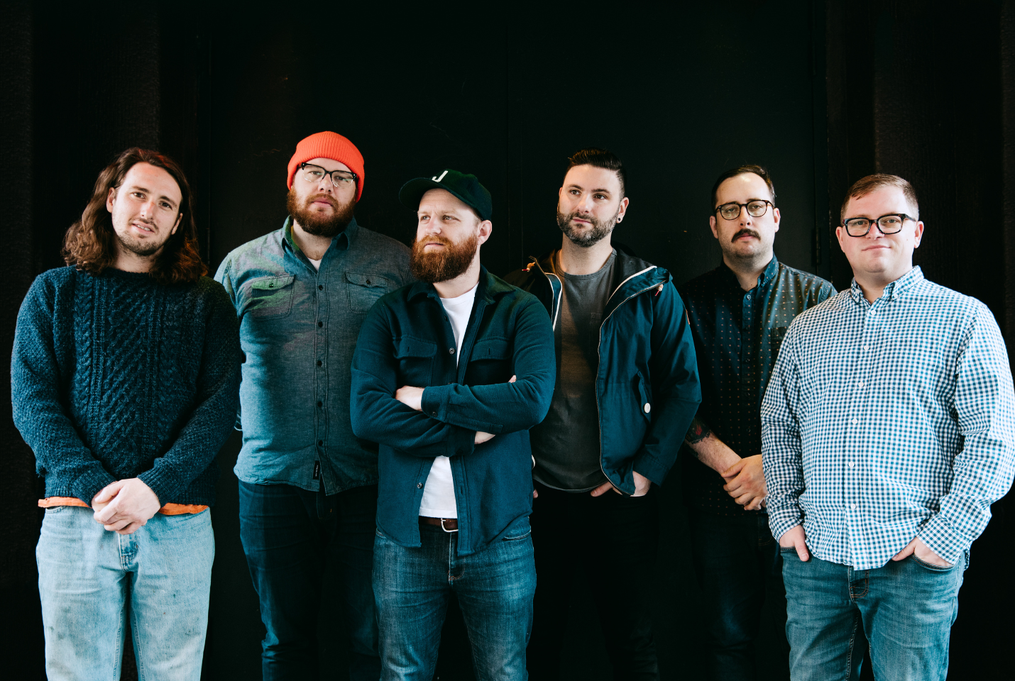 Artist The Wonder Years standing in front of dark green wall