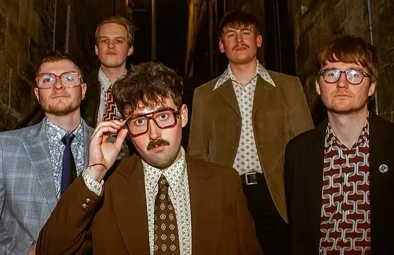 five men posing in suits, 3 of which wearing glasses