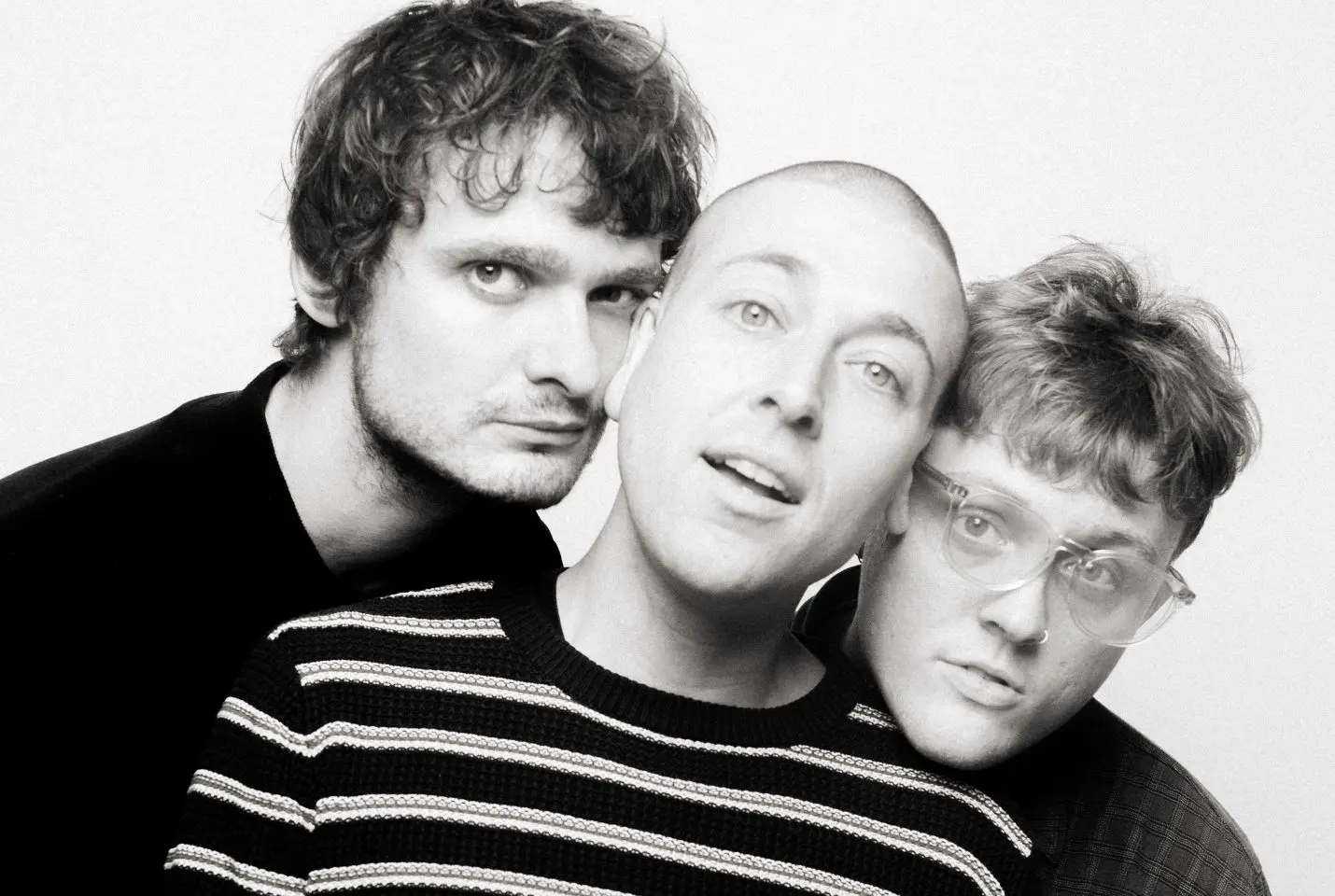 The three members of the band MOULD with their heads pressed together