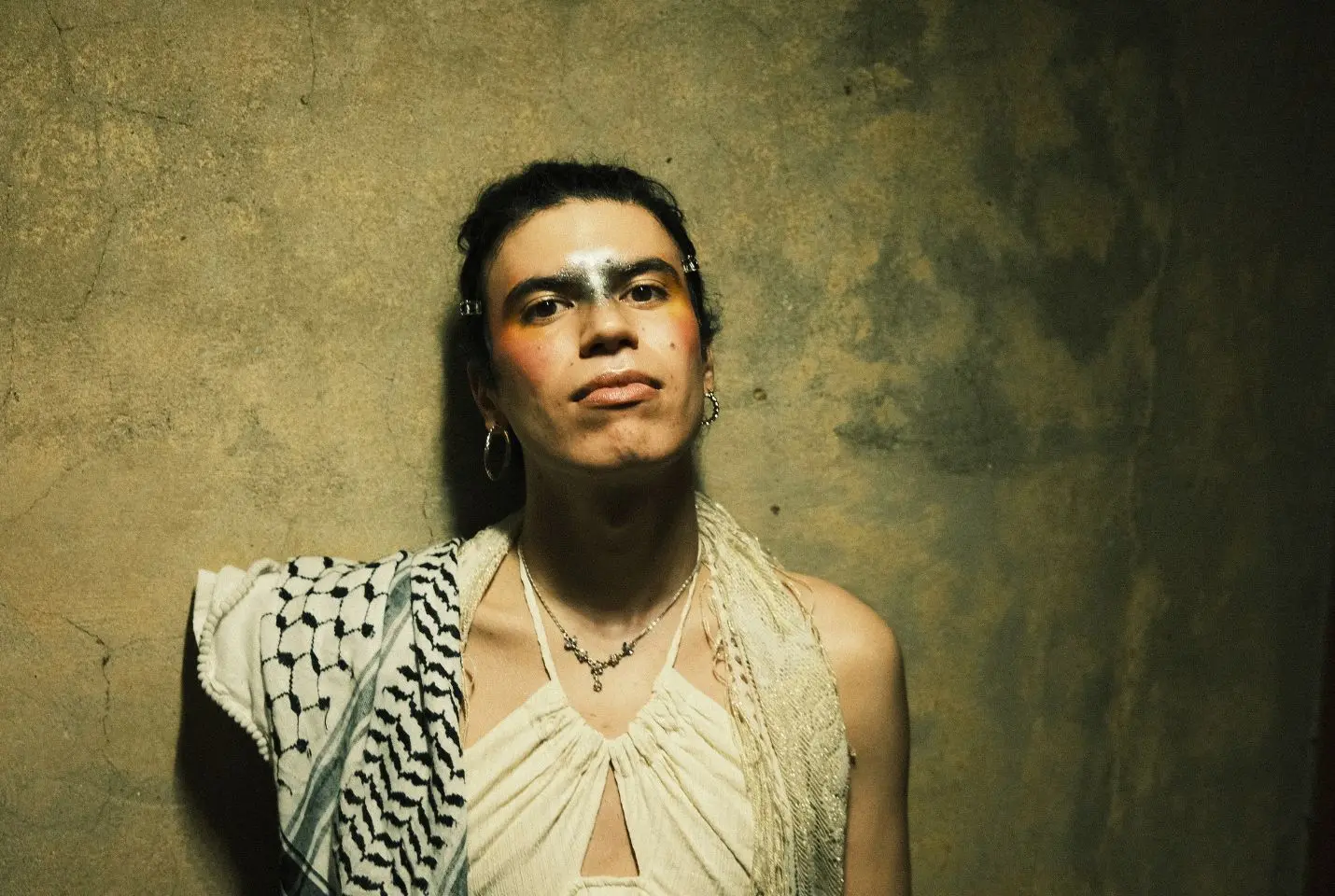 Jacob Alon wearing a white dress and keffiyah