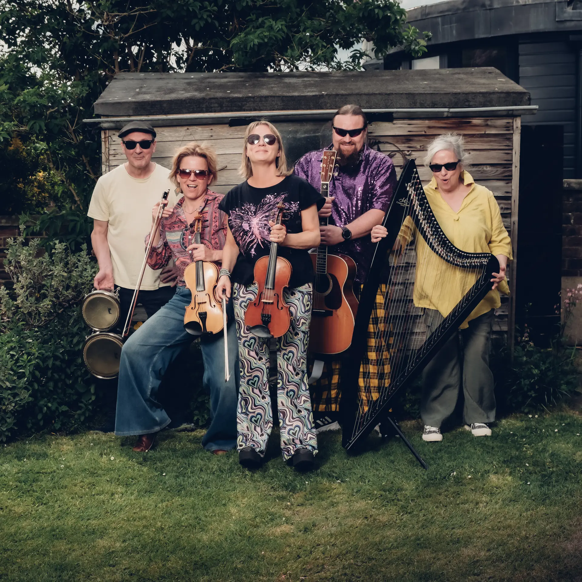 The Poozies posing in a garden with instruments