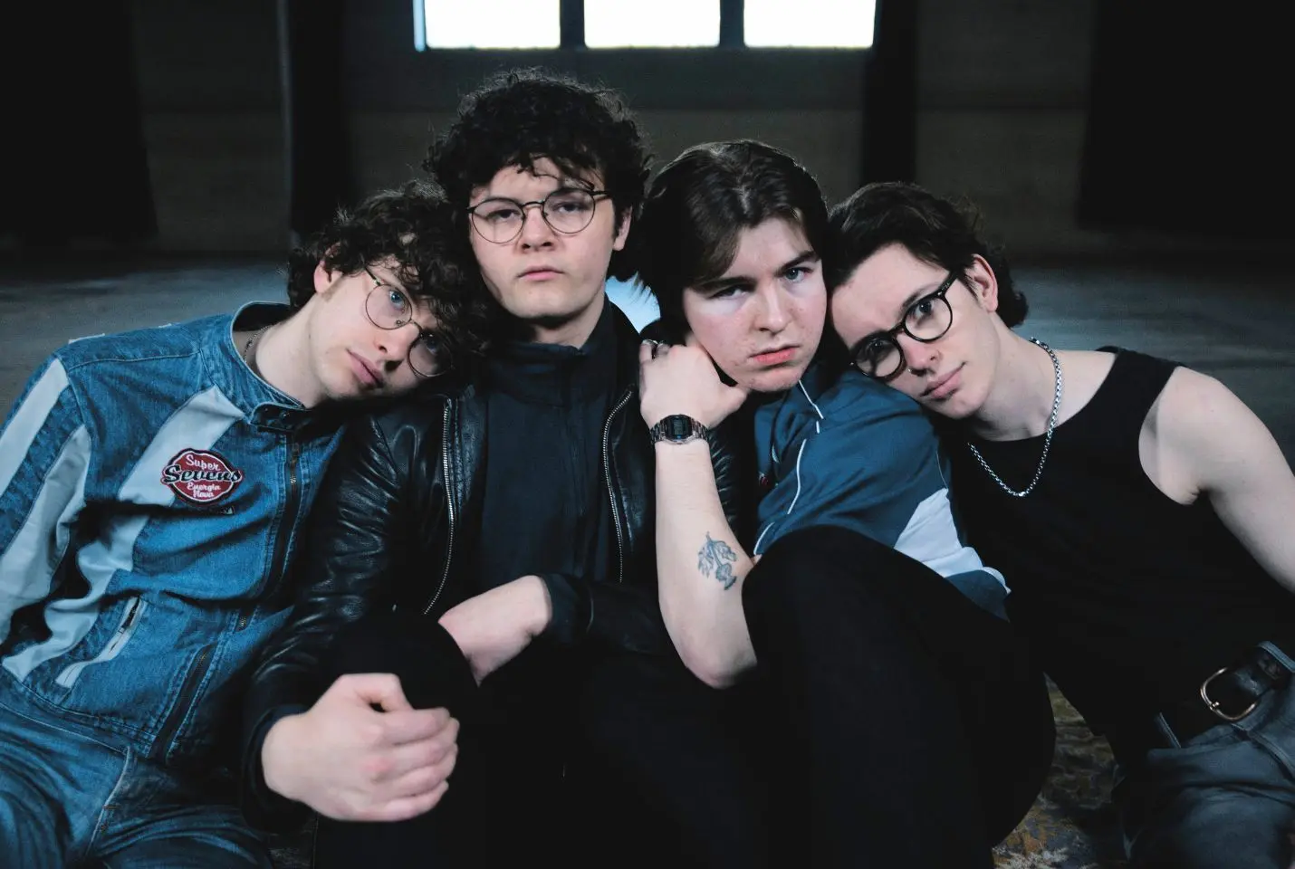 Four people sat in a large empty room