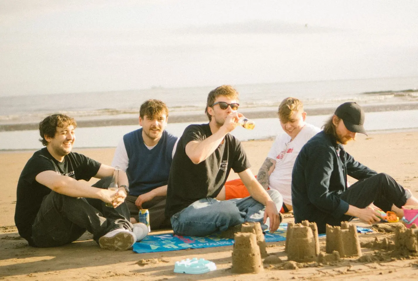 Band of 5 men posing on the beach