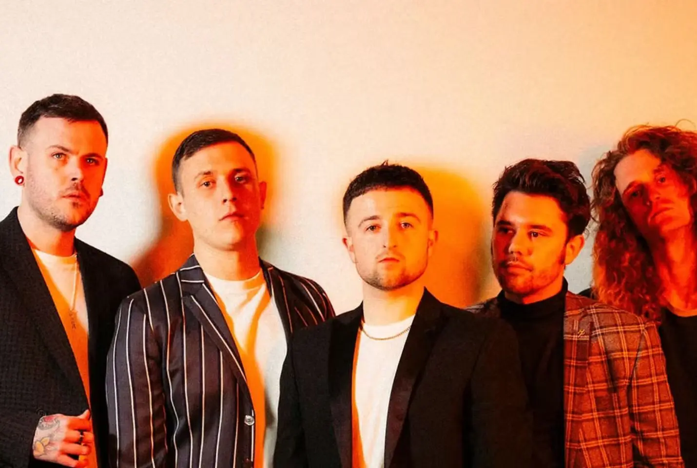 5 men posing in warm lighting