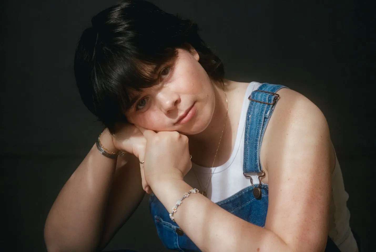 Leith Ross wearing a white vest and blue denim dunagrees