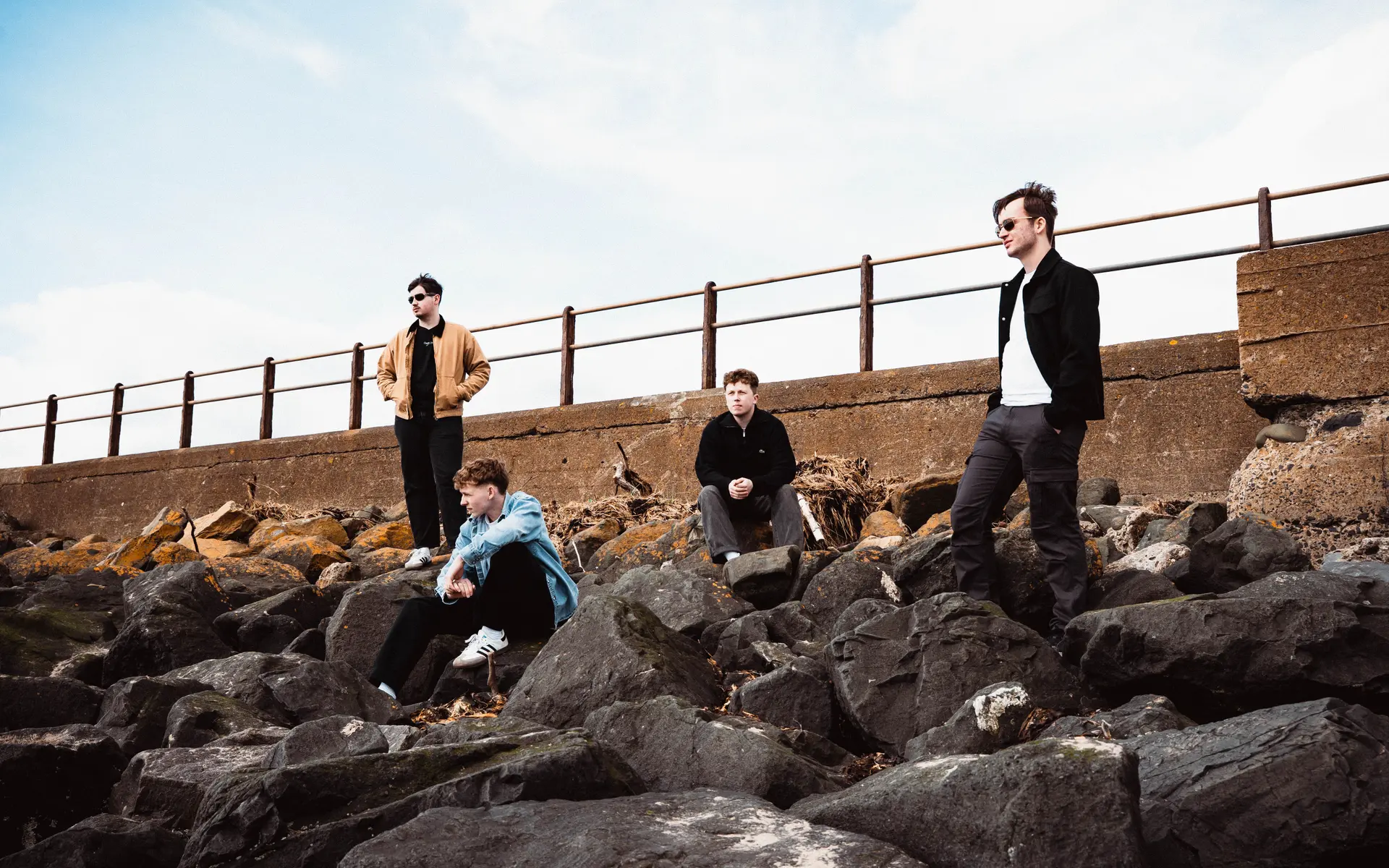 thr band mixed signals posing on rocks at the beach