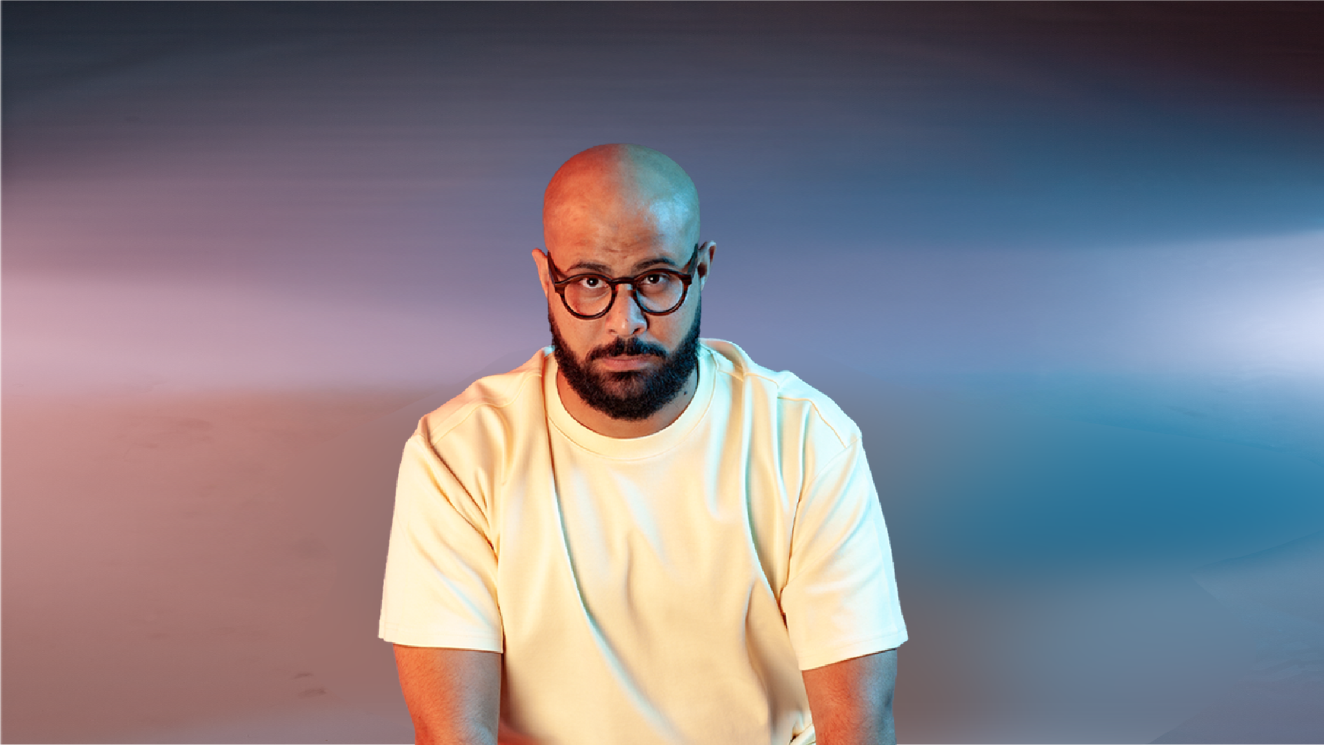 man white shirt, sitting, bald, black rim glasses, beard