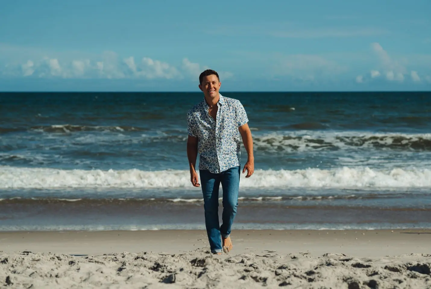 Scotty McCreery walking away from the ocean on the beach