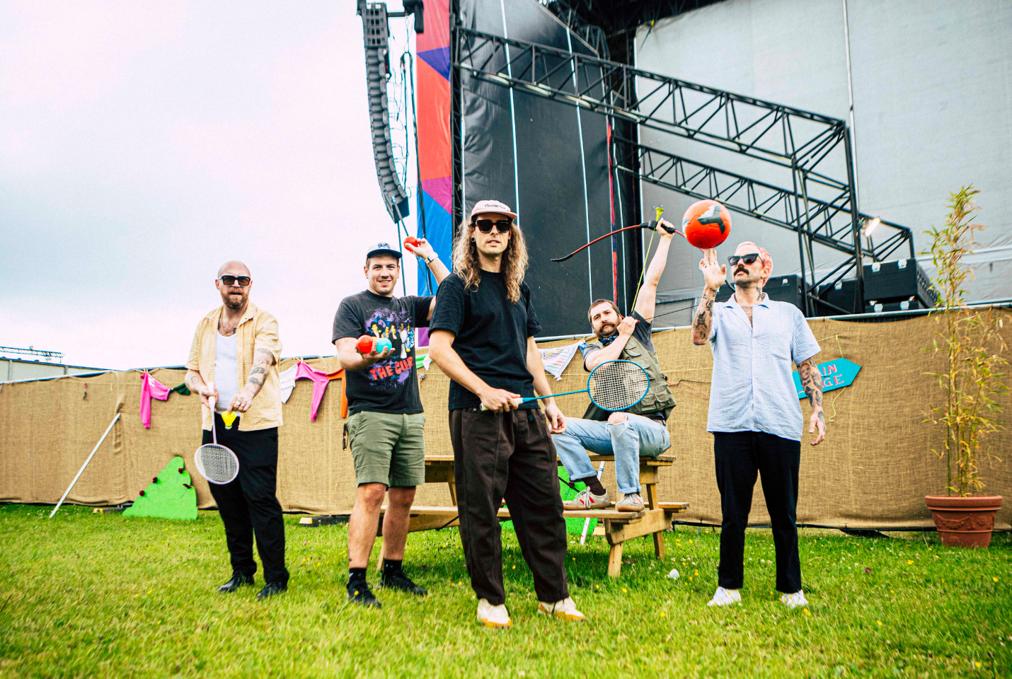 IDLES band outside playing ball and badminton