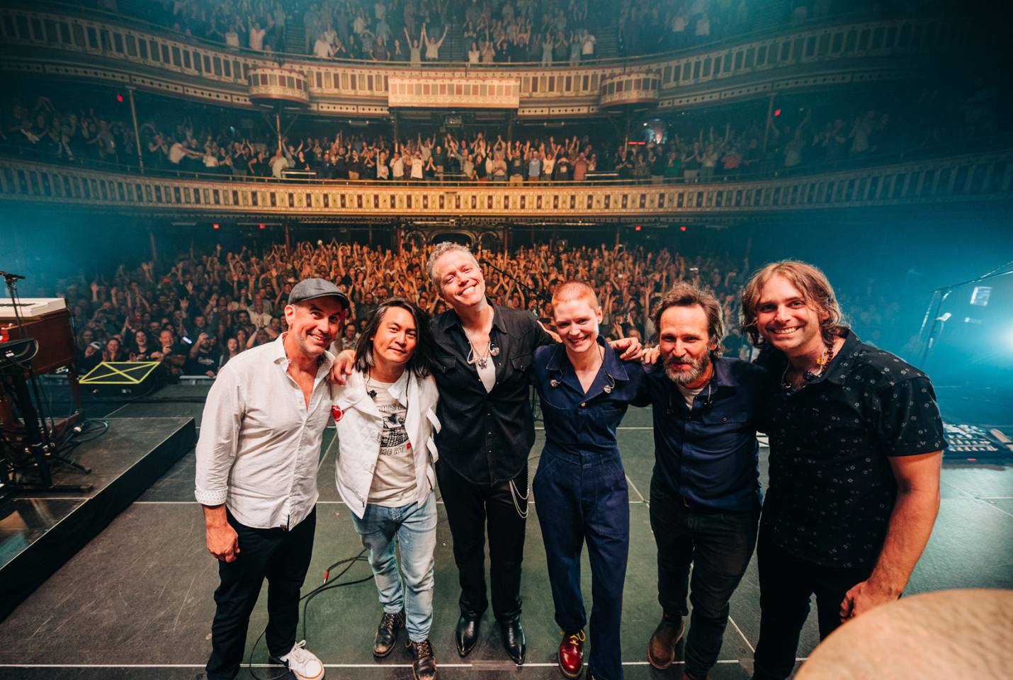 Jason Isbell and The 400 Unit on stage with crowd behind them.