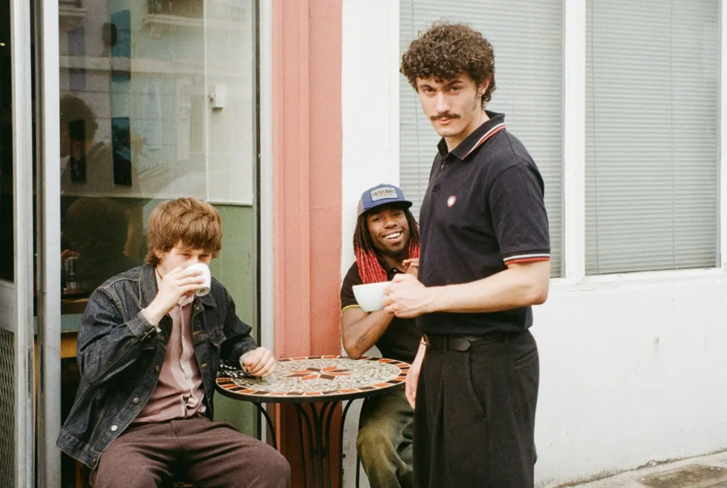 three men outside a coffee shop