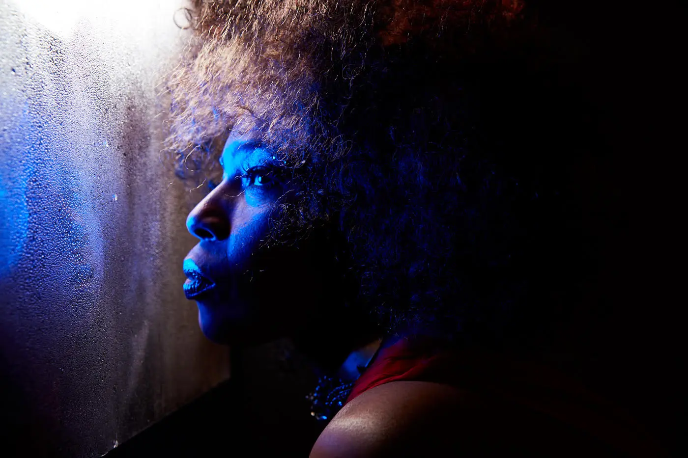 Macy Gray side profile dark lighting with blue UV light