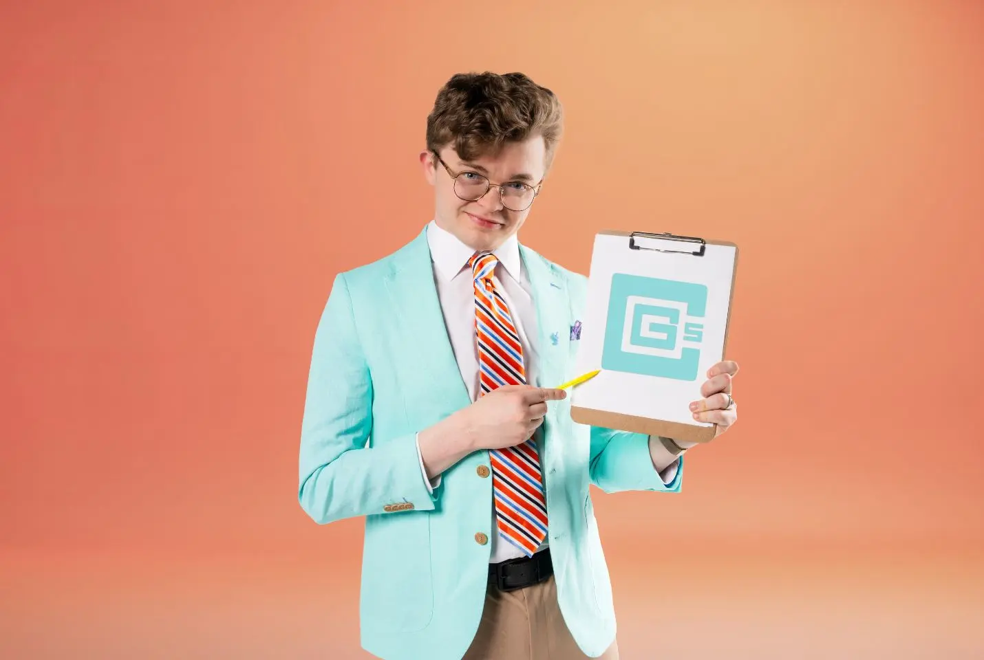 A man wearing a white shirt, brown trousers, blue jacket, striped tie, and glasses, holding a clipboard and pen stood in front of an orange background