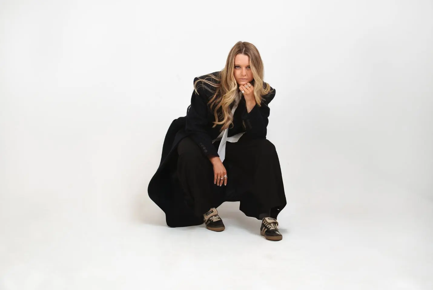 Lusaint kneeling for photograph wearing dark clothing