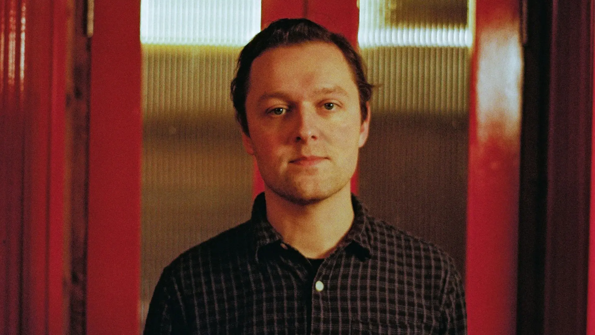 Joshua Burnside in front of a red door