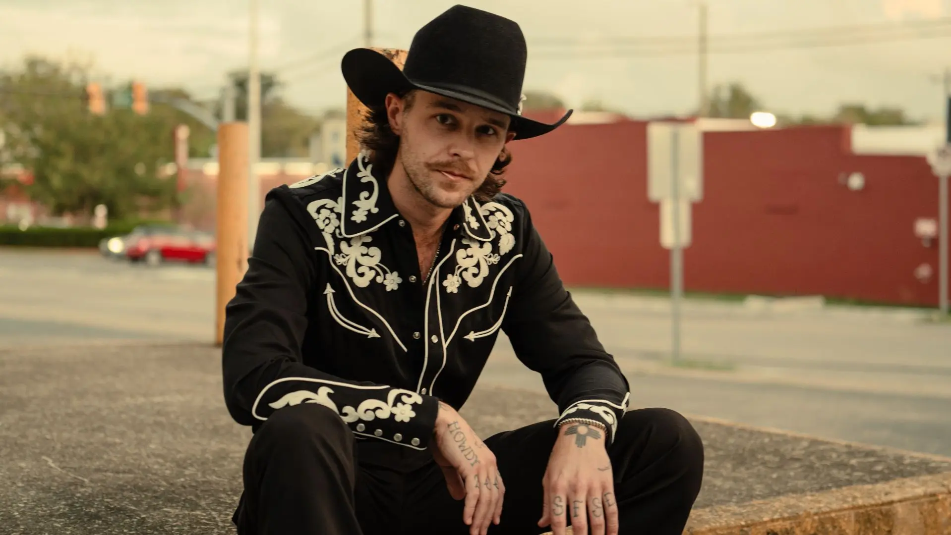 Tyler Halverson dressed in black with a black cowboy hat on