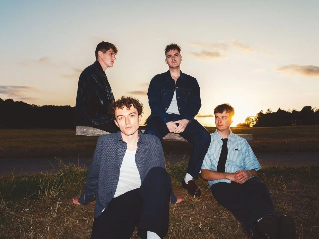 men posing with sunset in background