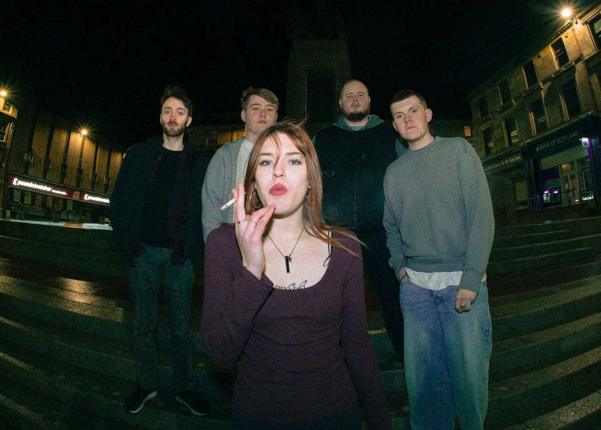 four men standing on steps with woman smoking cigarette