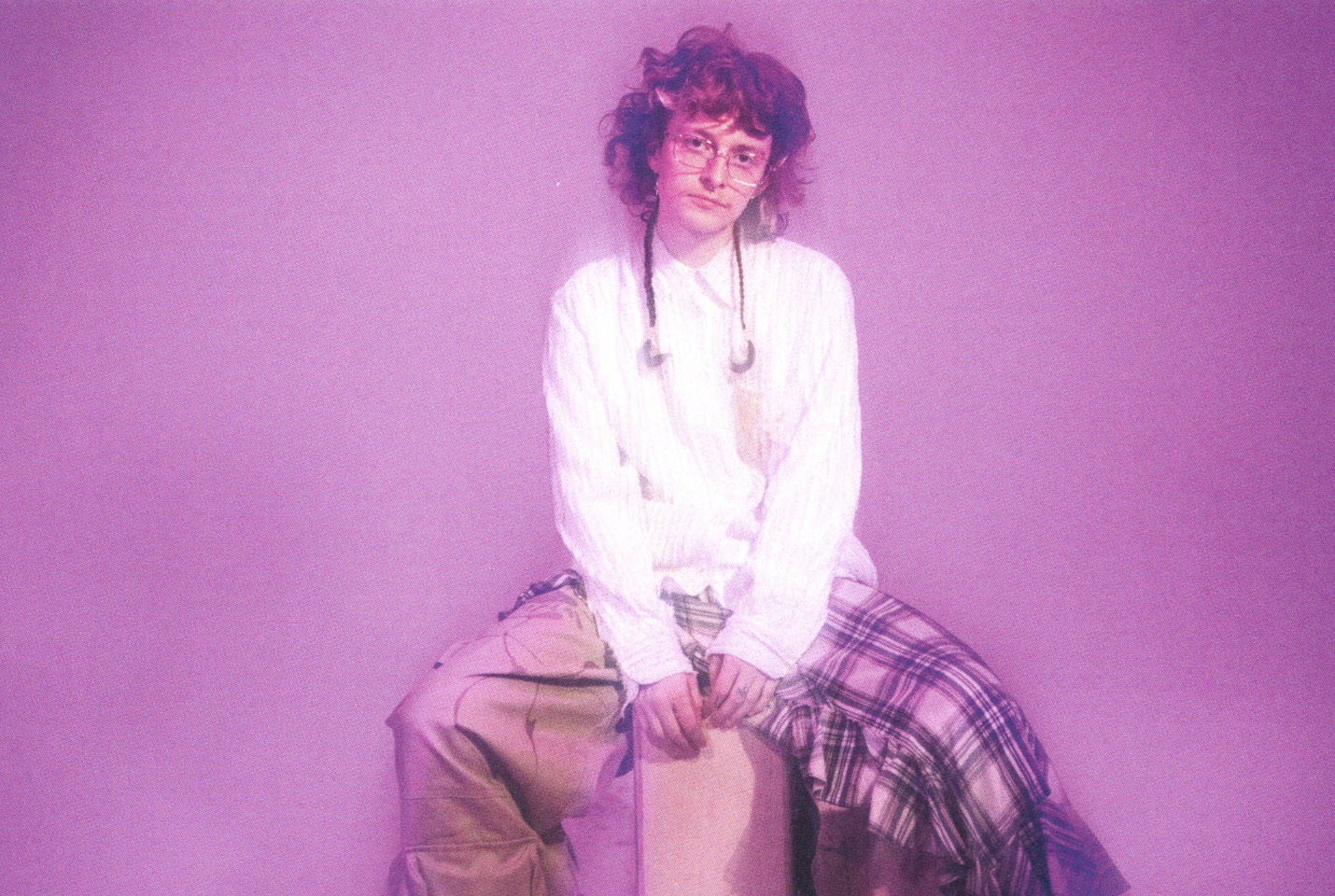 Artist Cavetown sitting against a pink background