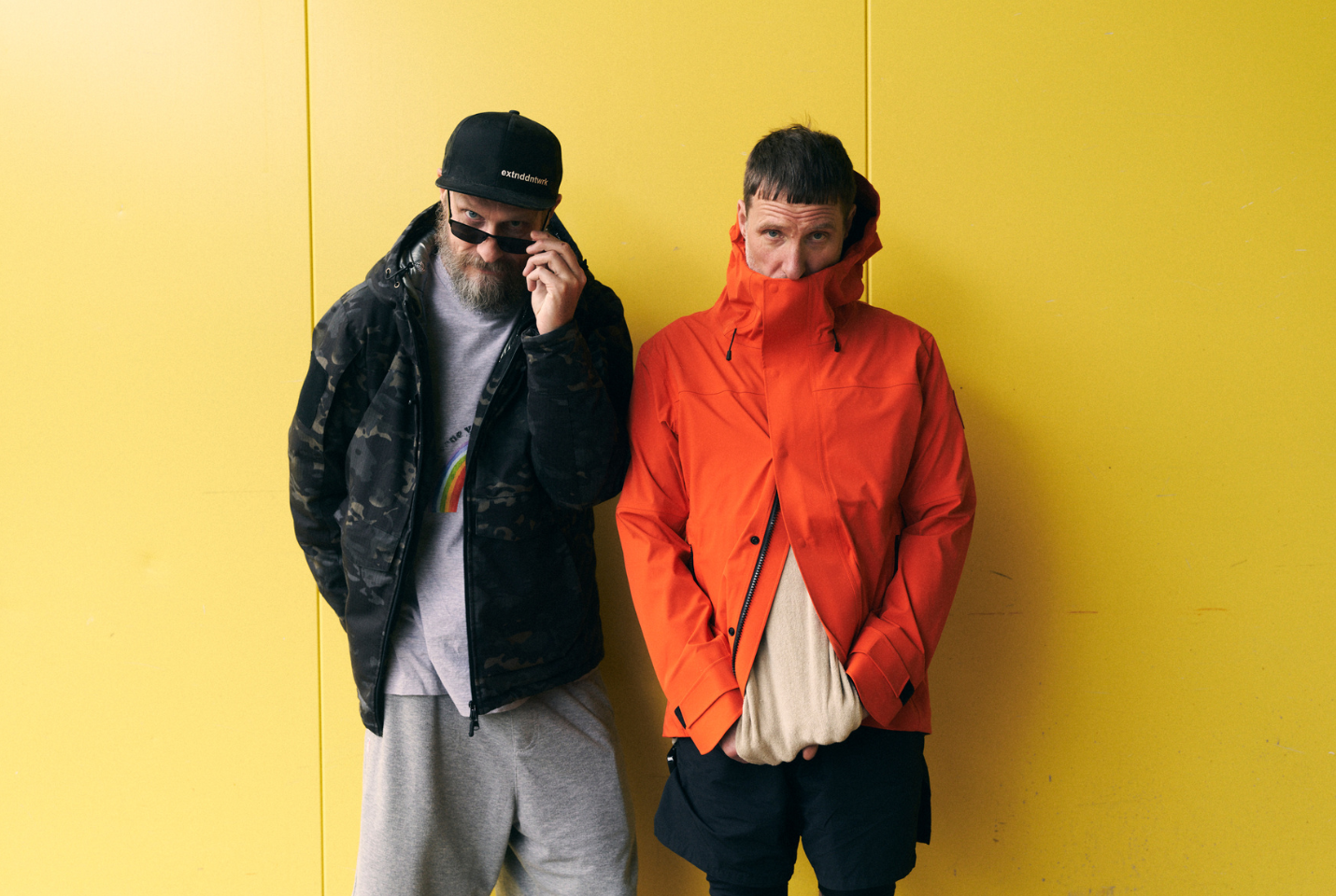 Artist Sleaford Mods standing in front of yellow wall