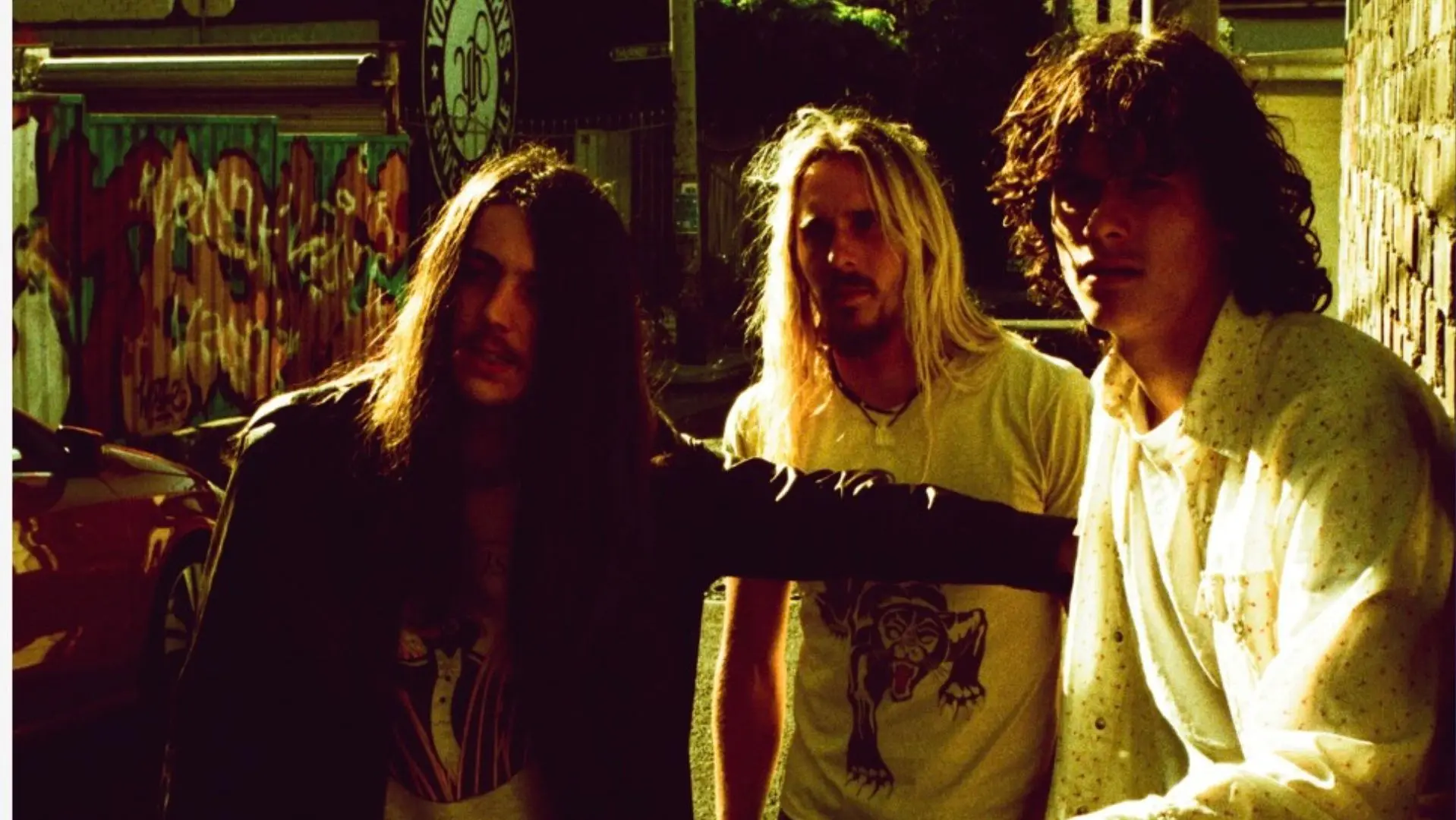 Trio HEADSEND stood against a wall