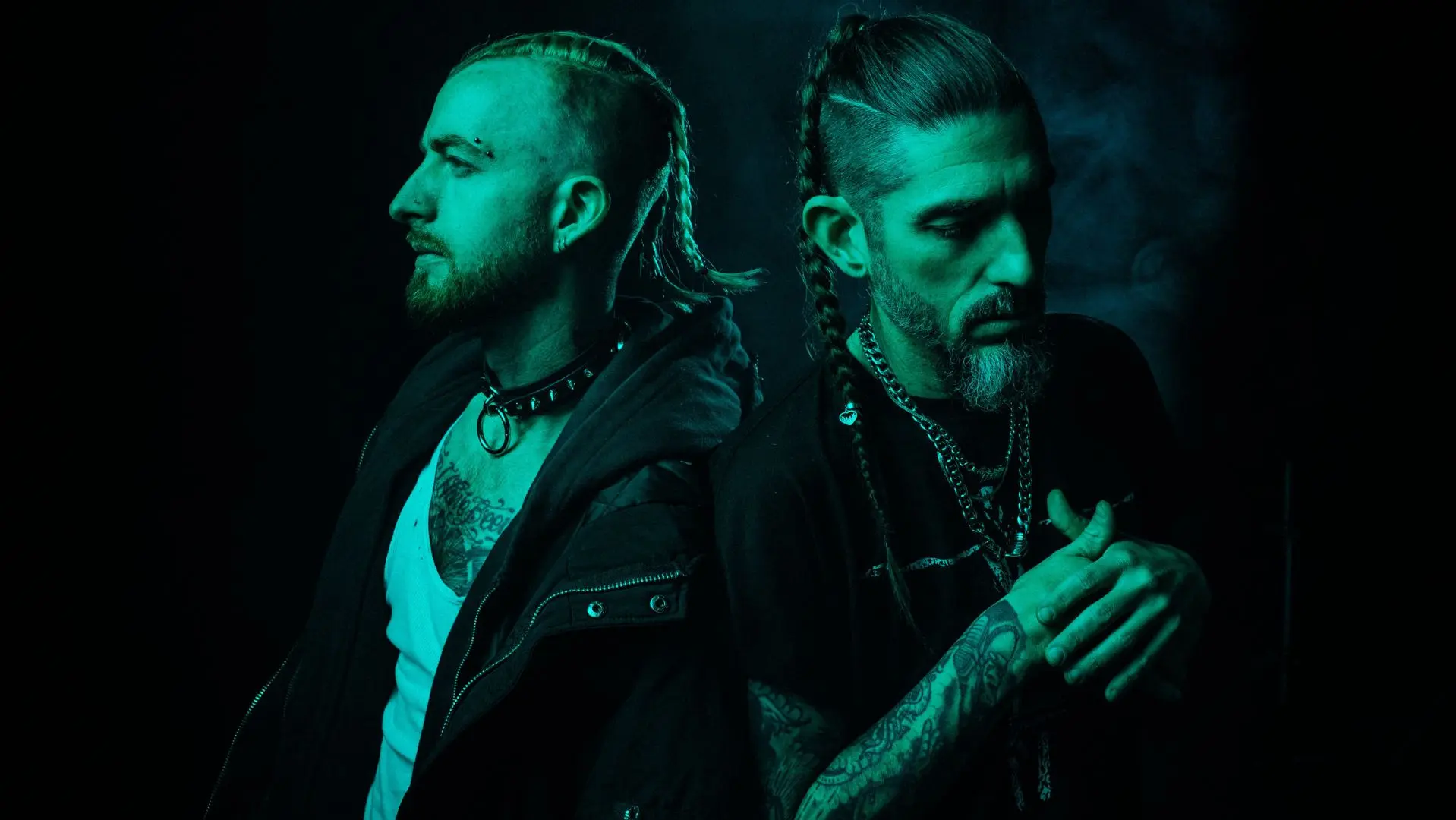 Duo Missio stood with their backs to each other, green tinted light shining around them